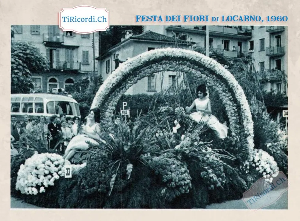 Festa dei fiori di Locarno 1960: un carro con un grande arco di garofani bianchi e due ragazze in abito da sera, con la folla e il filobus sullo sfondo